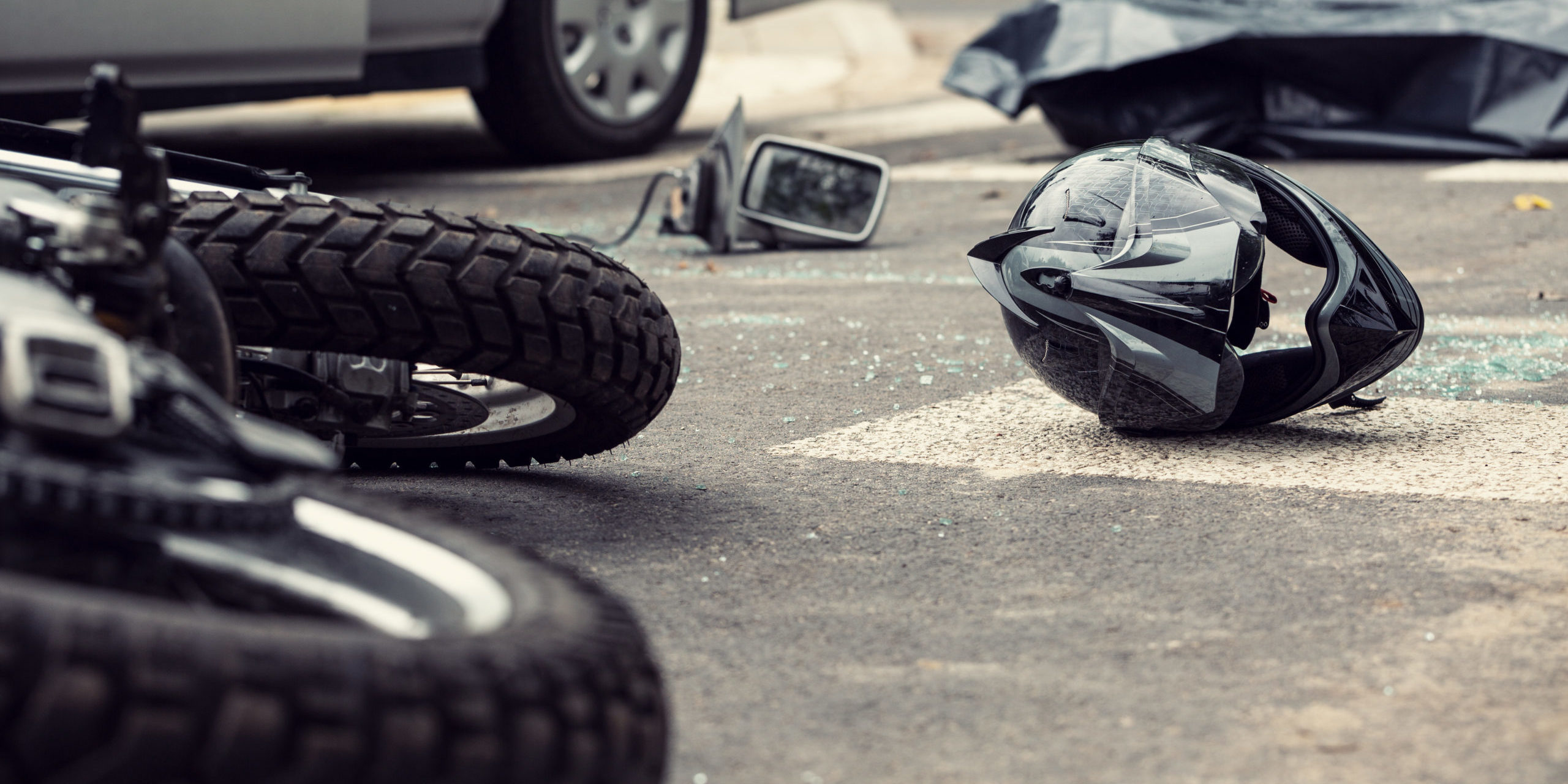Motorcycle and helmet on the street after dangerous traffic incident
